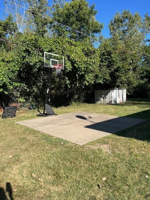 view of sport court featuring a lawn and basketball court