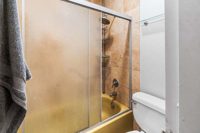 bathroom featuring shower / bath combination with glass door and toilet