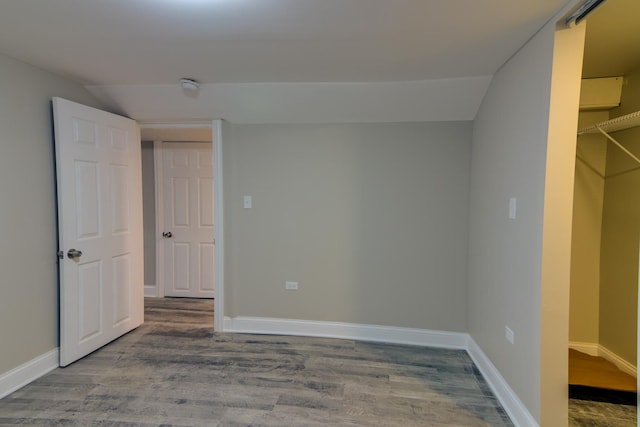 unfurnished bedroom featuring wood-type flooring and lofted ceiling