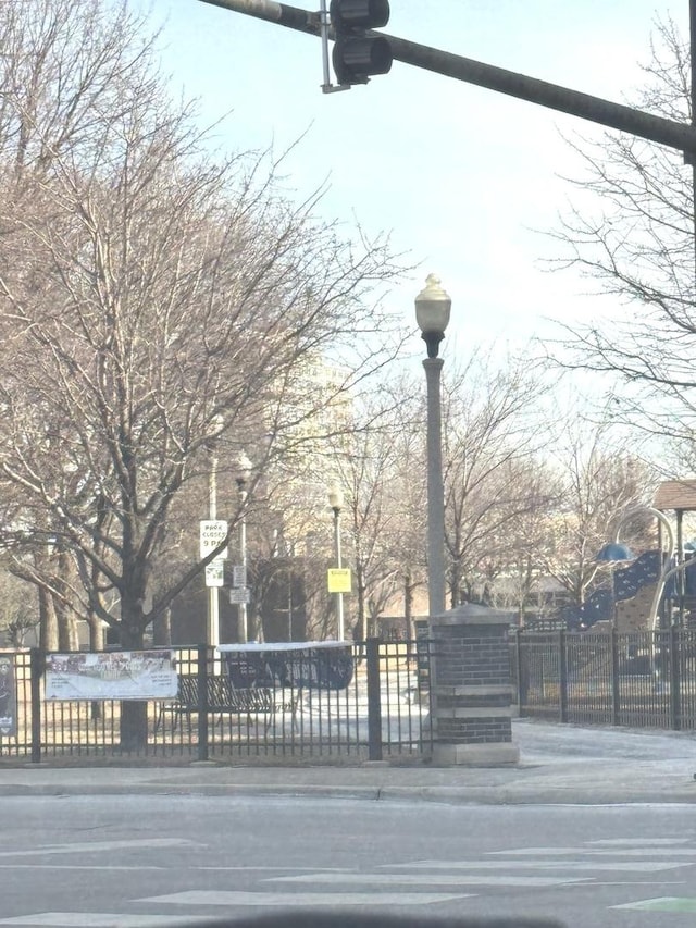 exterior space featuring curbs, street lighting, and traffic signs