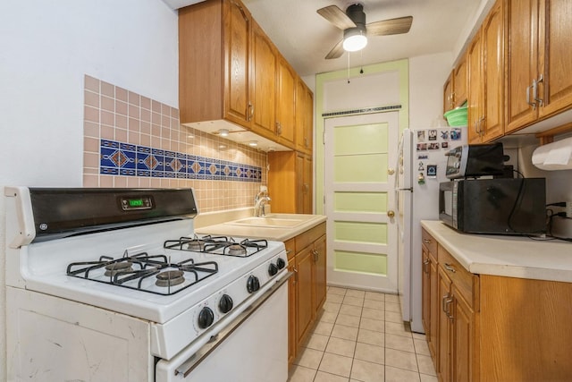 kitchen featuring sink, white appliances, light tile patterned floors, ceiling fan, and tasteful backsplash