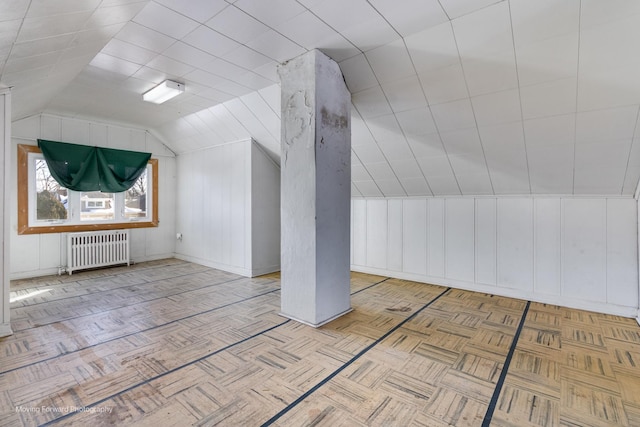 additional living space featuring radiator and lofted ceiling