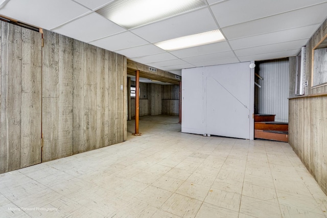 finished below grade area featuring a drop ceiling and tile patterned floors