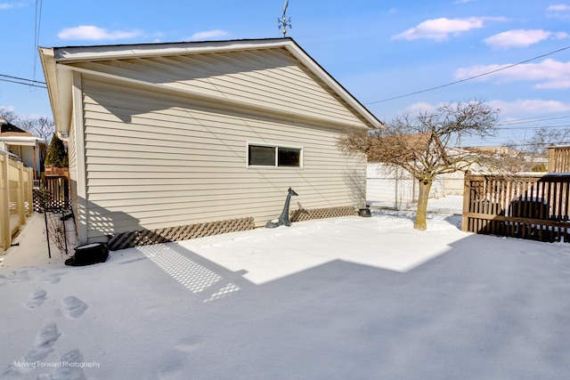 snow covered house featuring fence