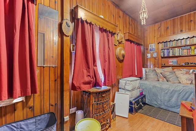 bedroom featuring a chandelier and wooden walls