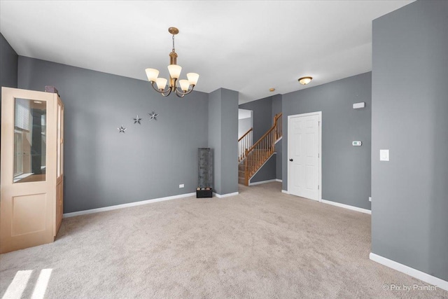 empty room featuring stairs, a chandelier, carpet flooring, and baseboards