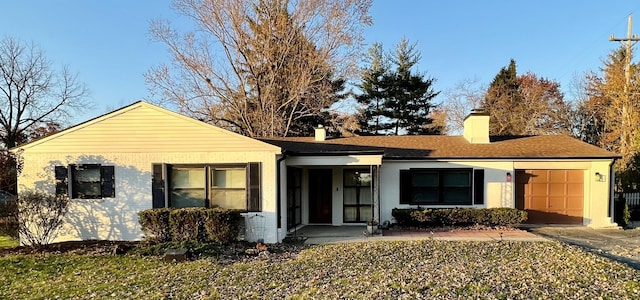 single story home with a garage, driveway, brick siding, and a chimney