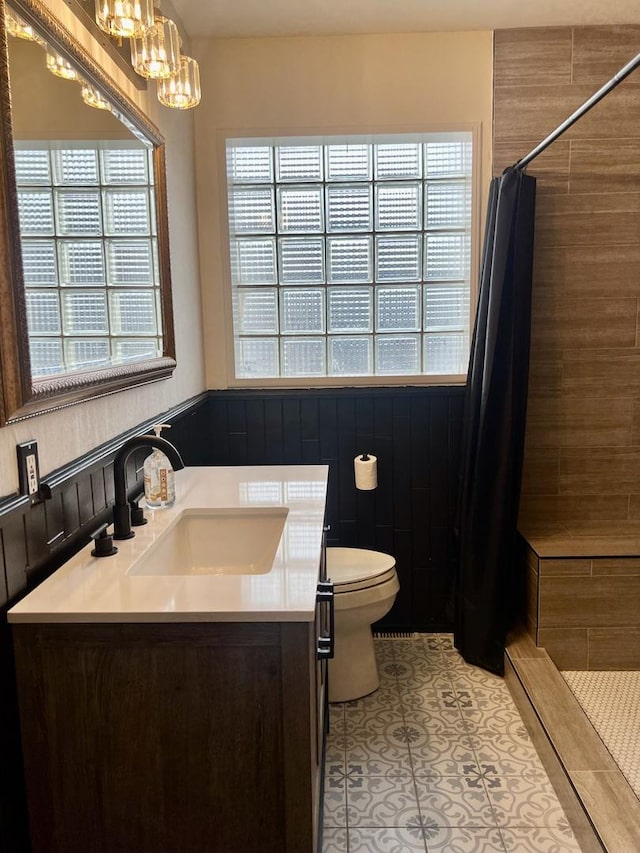 bathroom with a chandelier, toilet, vanity, a shower stall, and tile patterned floors