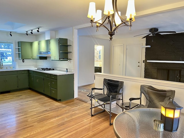 kitchen featuring light countertops, a sink, green cabinets, and open shelves