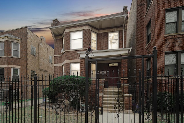 townhome / multi-family property featuring brick siding and a fenced front yard