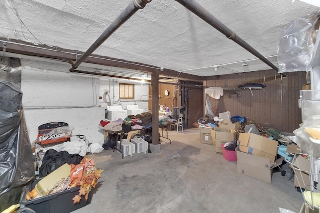 unfinished basement featuring independent washer and dryer and wood walls