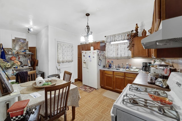 kitchen featuring white appliances, a sink, decorative backsplash, under cabinet range hood, and brown cabinets