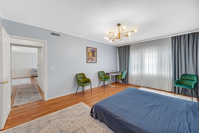 bedroom featuring ornamental molding, hardwood / wood-style floors, and a notable chandelier