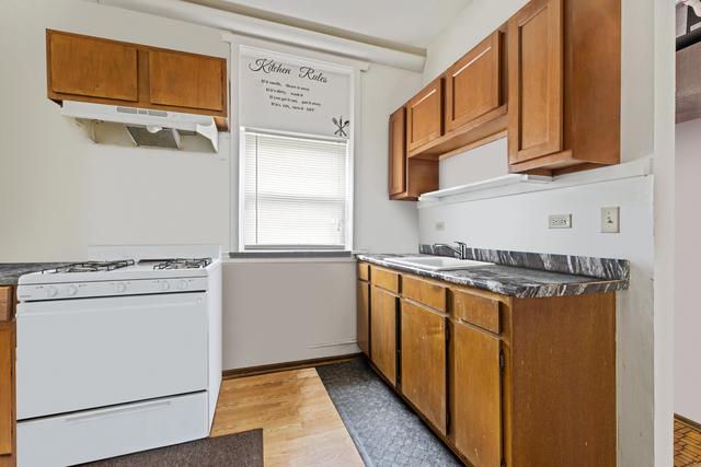 kitchen featuring sink, white gas range oven, and light hardwood / wood-style flooring