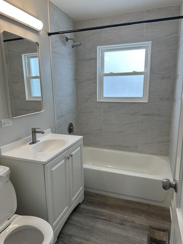 full bathroom with wood-type flooring, vanity, toilet, and tiled shower / bath