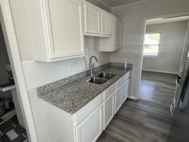 kitchen featuring sink, white cabinets, and stone countertops