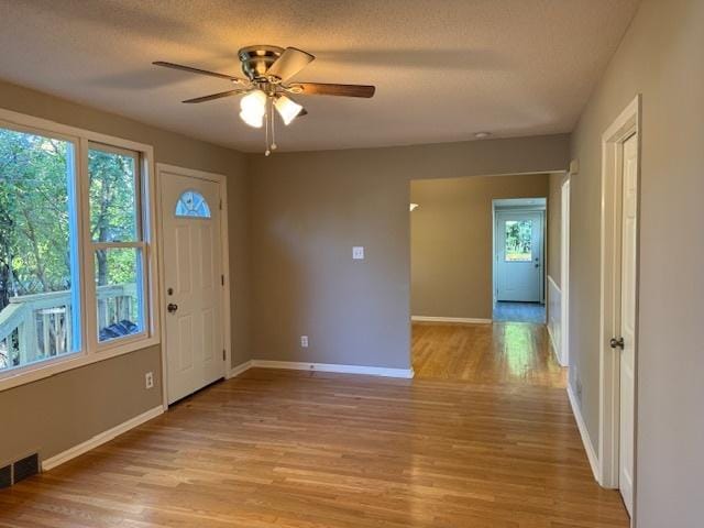 foyer with ceiling fan, light wood-type flooring, and a textured ceiling