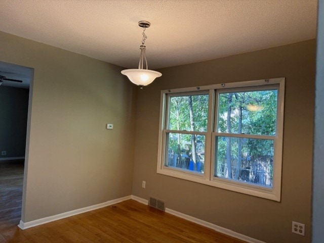 spare room featuring wood-type flooring and a textured ceiling