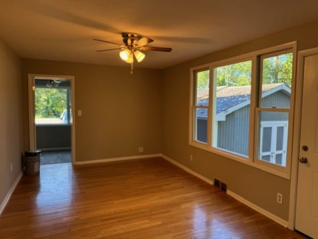 spare room featuring hardwood / wood-style flooring, plenty of natural light, and ceiling fan