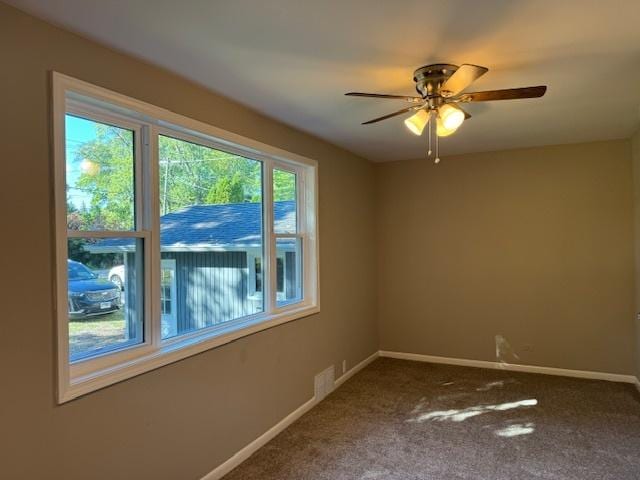 carpeted spare room featuring ceiling fan