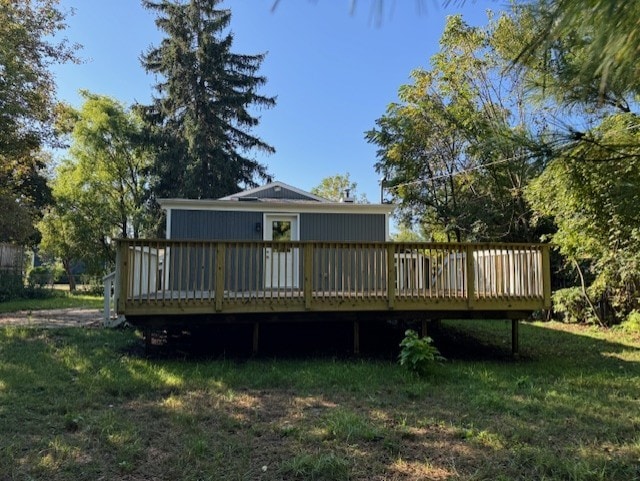 rear view of property featuring a lawn and a wooden deck