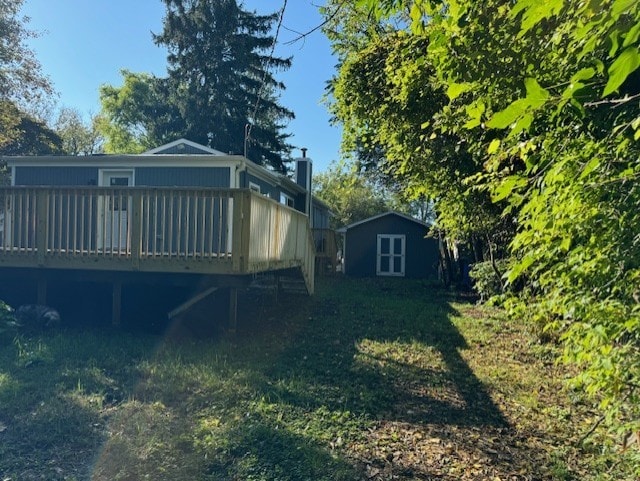 back of property featuring a storage unit and a wooden deck