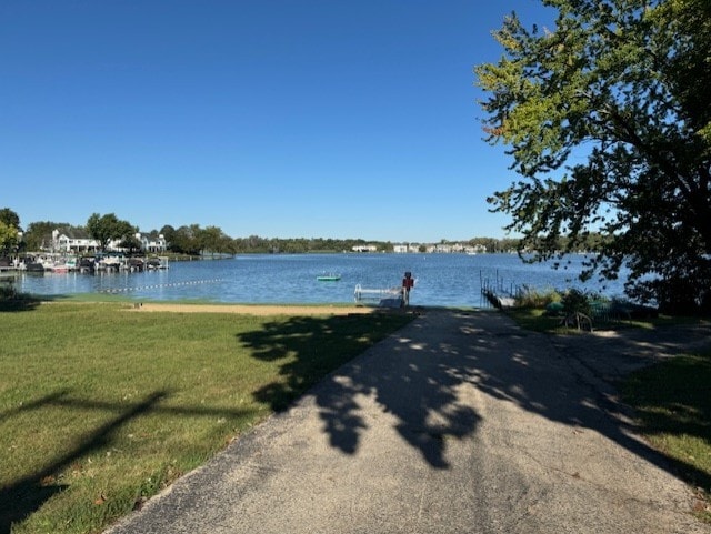 dock area with a yard and a water view