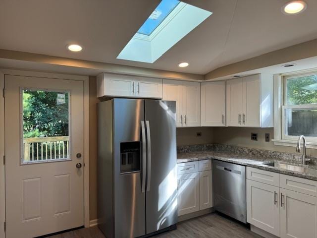 kitchen featuring sink, light stone counters, white cabinetry, dark hardwood / wood-style floors, and stainless steel appliances