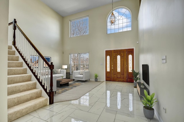 entryway with stairs, baseboards, and marble finish floor