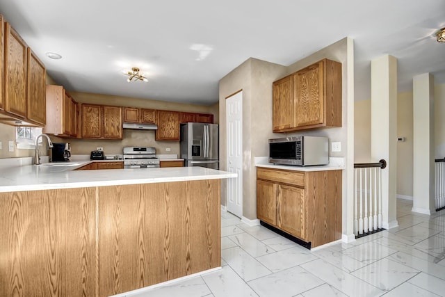 kitchen featuring marble finish floor, stainless steel appliances, light countertops, and a sink