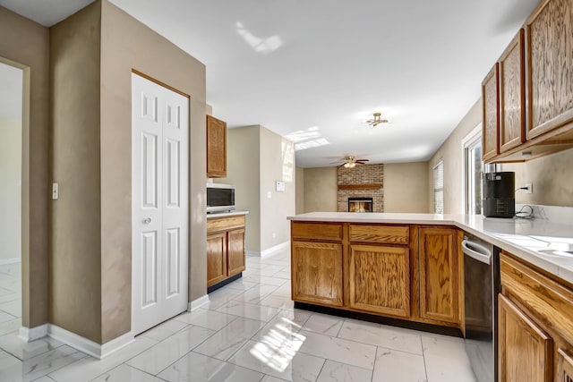 kitchen featuring a peninsula, a fireplace, light countertops, stainless steel microwave, and marble finish floor