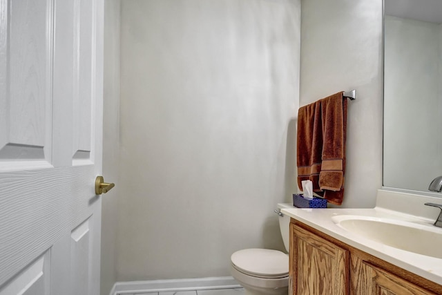 half bath featuring vanity, toilet, and baseboards