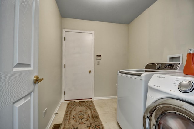 laundry room featuring laundry area, baseboards, and washing machine and clothes dryer