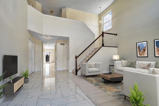 living room featuring stairs, visible vents, baseboards, and marble finish floor