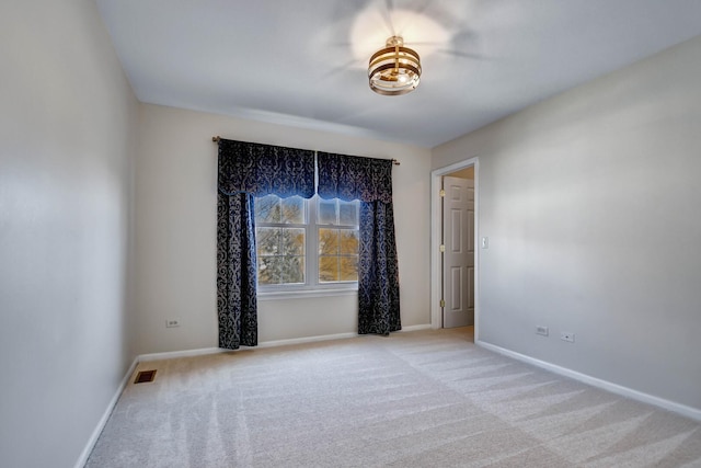 unfurnished room featuring light colored carpet, visible vents, and baseboards