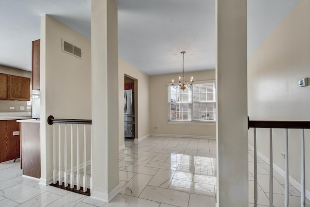 interior space featuring visible vents, baseboards, a notable chandelier, and marble finish floor