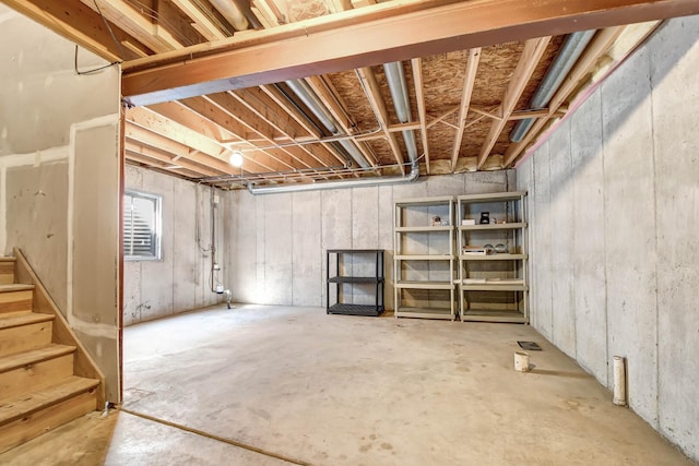 unfinished basement featuring stairs