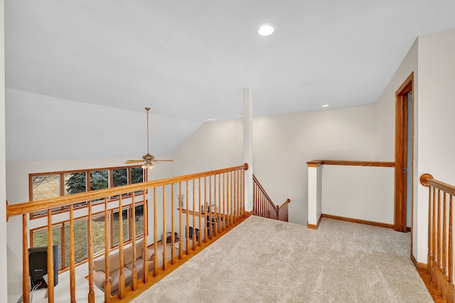 hall with lofted ceiling and light colored carpet