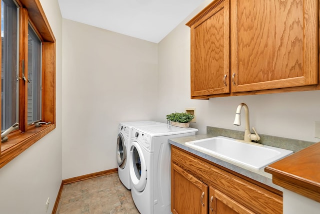 washroom with sink, cabinets, and washer and clothes dryer