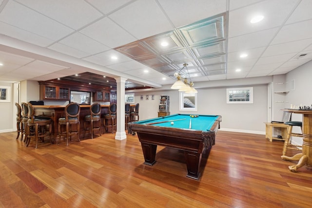 recreation room with a bar, baseboards, wood finished floors, and recessed lighting