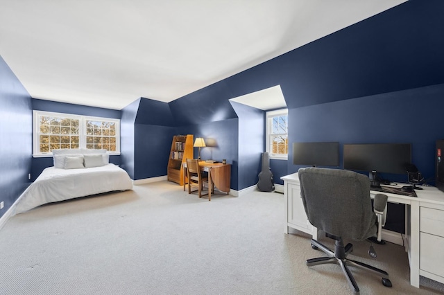 bedroom with light colored carpet, vaulted ceiling, and baseboards