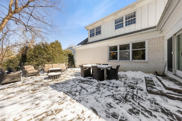 snow covered deck with outdoor dining area and outdoor lounge area