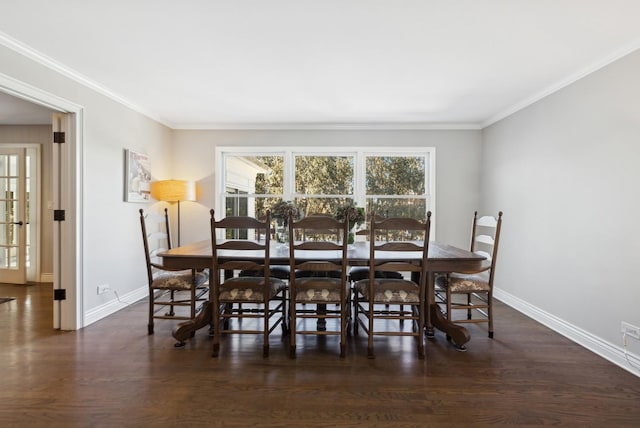 dining room featuring dark wood-style flooring, crown molding, and baseboards