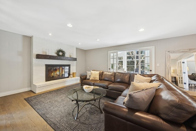 living room with light wood finished floors, a fireplace, baseboards, and recessed lighting