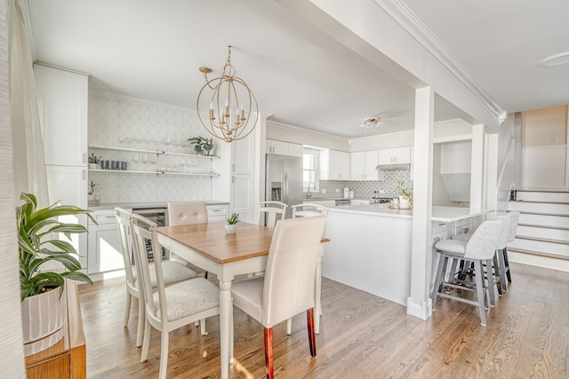 dining room featuring light wood-type flooring and crown molding