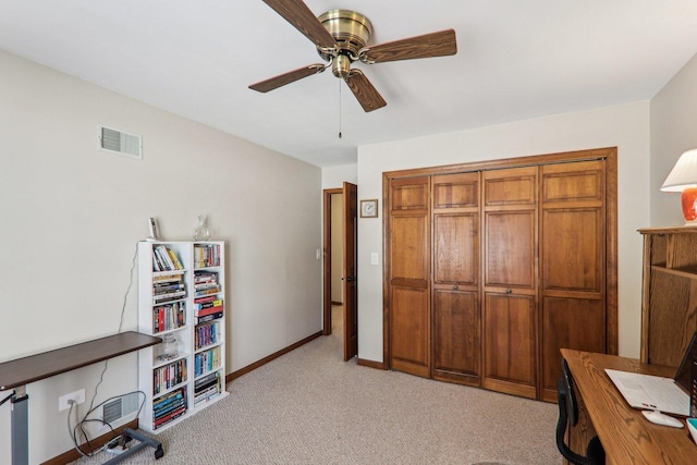 home office featuring light carpet and ceiling fan