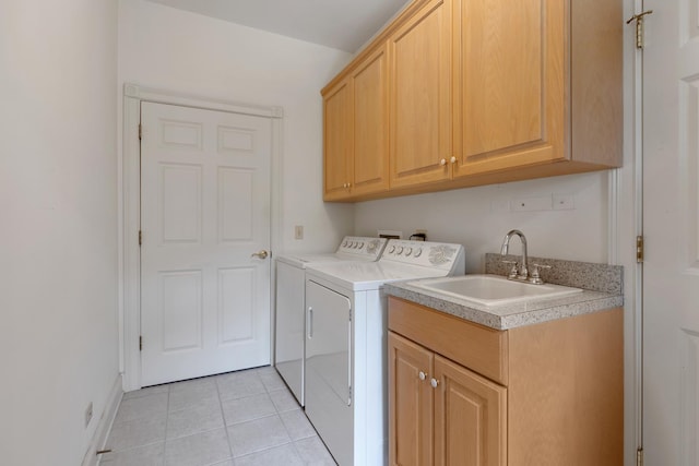 clothes washing area with cabinets, light tile patterned floors, sink, and washing machine and clothes dryer