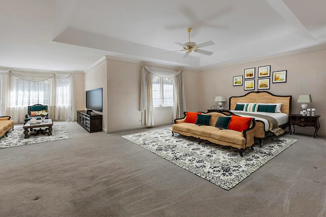 carpeted bedroom with ceiling fan, ornamental molding, and a raised ceiling