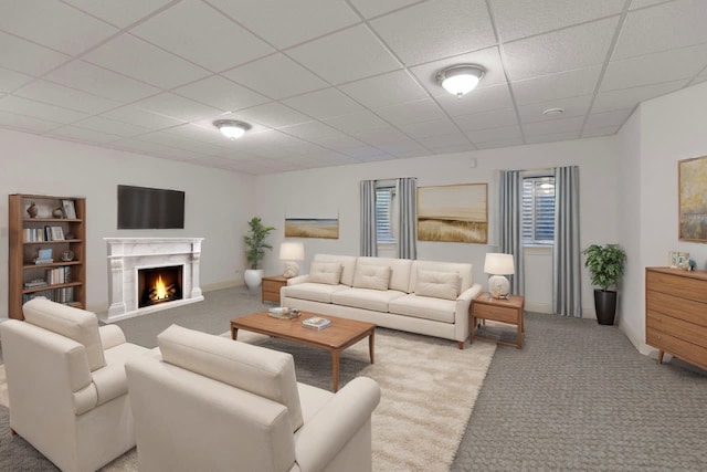 living room featuring a fireplace, light carpet, and a paneled ceiling