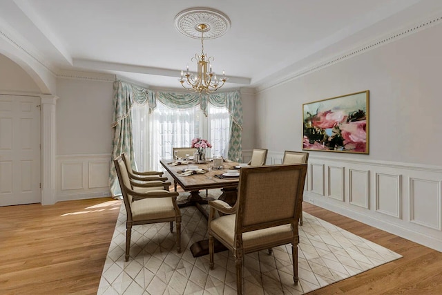 dining area with light hardwood / wood-style floors and a chandelier